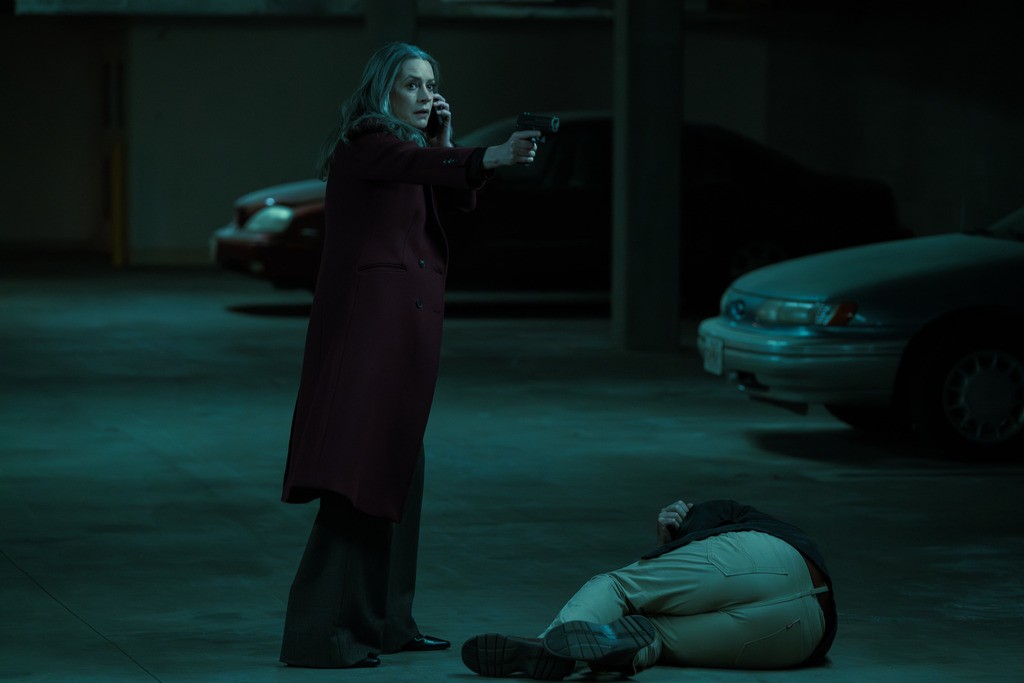 Dans un sombre parking, un homme est au sol et Prentiss braque son arme.